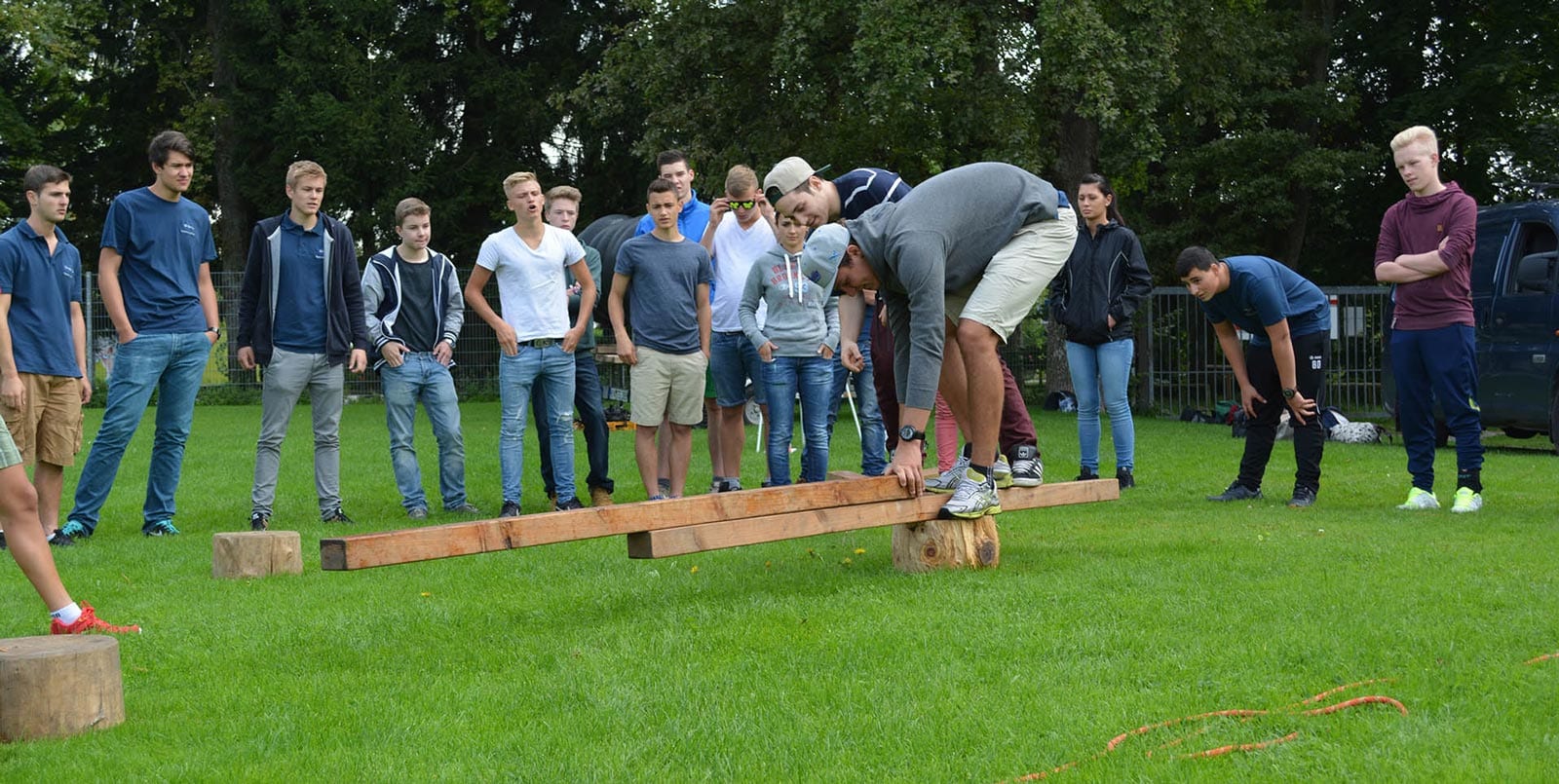 Gruppe Jugendlicher beim Outdoor-Teamspiel auf Gras