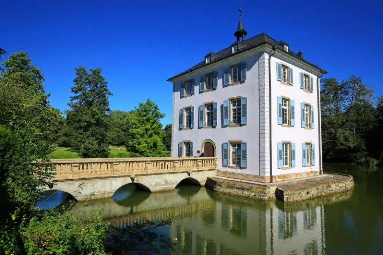 Schloss im Park auf Insel mit Brücke